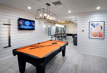 a pool table in a game room with a tv